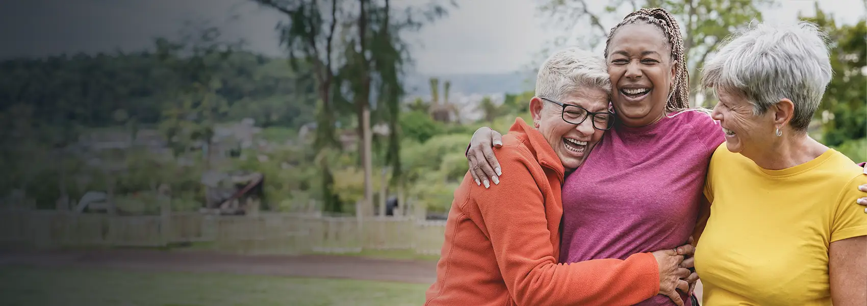 Three women laughing holding each other